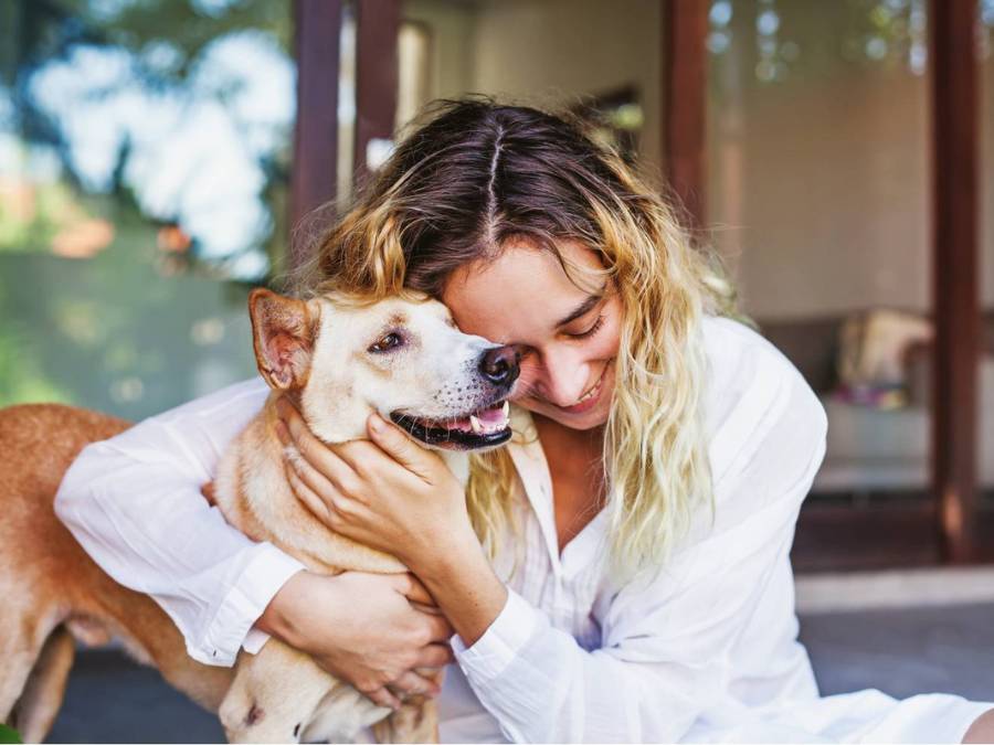 Happy woman hugging her dog outdoors